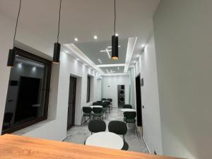 a group of tables and chairs in a room at Pastorian Hotel in Maliq