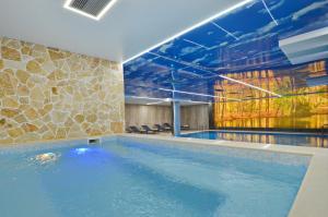 a large swimming pool in a building with a painting on the wall at Hotel Aleksandar Conference & Spa in Žabljak