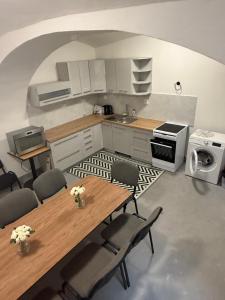 a kitchen with a table and chairs and a sink at Penzion Vis a Vis in Třebíč +28 photos