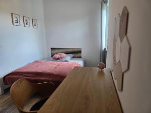 a small bedroom with a bed and a wooden table at Ferienwohnung Lux in Ortenberg +4 photos