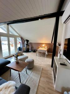 a living room with a couch and a table at Glamping Cabin Wilderness bathing and relaxation in Silkeborg