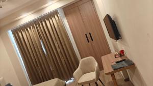a room with a desk and a chair and a door at Romaer's Room in Greater Noida