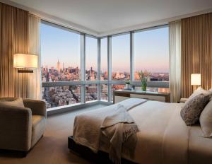 una camera da letto con una grande finestra con vista sulla città di The Dominick Hotel a New York