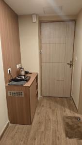 an empty room with a kitchen with a door at Romaer's Room in Greater Noida