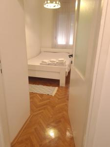 a small room with a bed and a hallway at Serenity City Centre in Podgorica