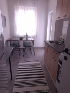 a kitchen with a sink and a table with chairs at Serenity City Centre in Podgorica