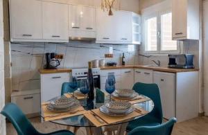 a kitchen with a table and chairs and white cabinets at Villa Marcella by the Sea in Kamisianá