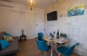 a dining room with a table and blue chairs at Villa Marcella by the Sea in Kamisianá