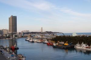 a river with boats docked in a city at Ocean Hotel Pohang in Pohang
