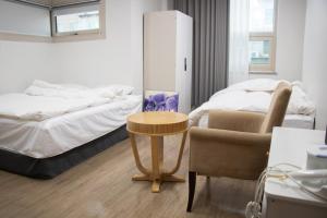 a bedroom with a bed and a table and a chair at Ocean Hotel Pohang in Pohang