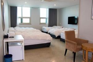 a hotel room with four beds in a row at Ocean Hotel Pohang in Pohang +6 photos