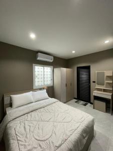 a bedroom with a large bed and a desk at The Smoke Shop in Ban Suan