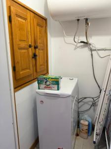a small kitchen with a white refrigerator and a wooden cabinet at Casita Loredo in Mieres