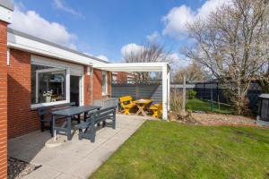a patio with a picnic table and chairs in a yard at Deichgraf in Dornumersiel