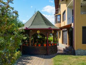 a gazebo with potted plants on it next to a building at Casa RUXI in Jiblea Veche
