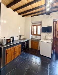 a large kitchen with wooden cabinets and a white appliance at Casita Loredo in Mieres