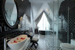 a black bathroom with a tub and a sink at TTR Skypool View Hotel - Đà lạt in Da Lat +168 photos