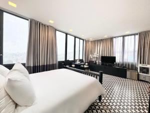 a bedroom with a large bed and large windows at TTR Skypool View Hotel - Đà lạt in Da Lat