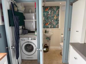 a small bathroom with a washing machine in it at York Cottage in Southwold
