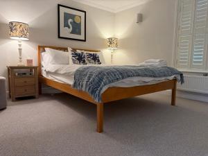 a bed in a bedroom with two lamps and a bed sidx sidx sidx at York Cottage in Southwold