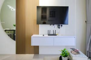 a living room with a tv on a white dresser at Piccadilly Service Residence Greentown Ipoh in Ipoh