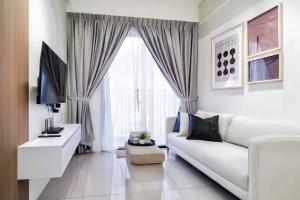 a white living room with a white couch and a window at Piccadilly Service Residence Greentown Ipoh in Ipoh