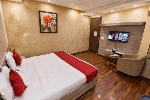 a hotel room with a bed and a tv at Mauryan Elite Hotel Vasant Kunj in New Delhi +16 photos