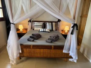 a bedroom with a bed with a canopy at Le Jardin du Saloum in Toubakouta