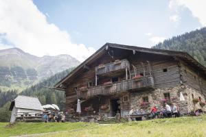 a group of people sitting outside of a building at Hochalmbahnen Chalets 1-03, Alpenrose, nahe Gondel, Hunde willkommen in Rauris