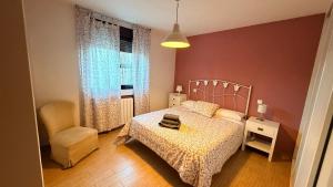 a bedroom with a bed and a chair at El Rincon De Los Abuelos in Tudela de Duero
