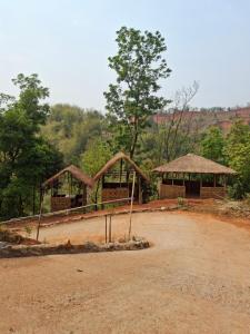 a couple of buildings with trees in the background at Ribhoi Jungle in Khānāpāra