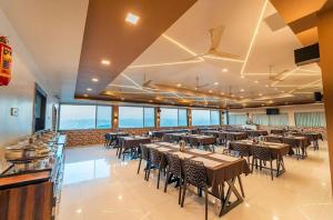 a restaurant with tables and chairs in a room at Kaizen Stays And Resto in Panchgani