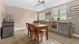a kitchen with a table and chairs in a room at Vine Cottage in Thornham