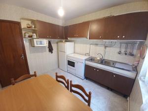 a kitchen with a table and a sink and a counter at Casa O Capitán in Corcubión +10 photos
