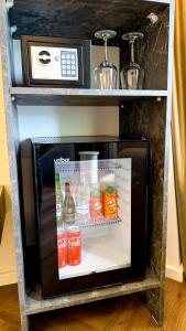 a small refrigerator with drinks inside of it at Vatër Selected Rooms in Tirana +109 photos