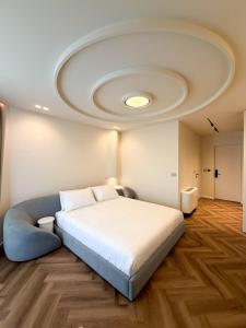 a bedroom with a large bed and a ceiling at Vatër Selected Rooms in Tirana