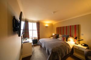 a bedroom with a bed and a television in it at The Pier Hotel in Harwich
