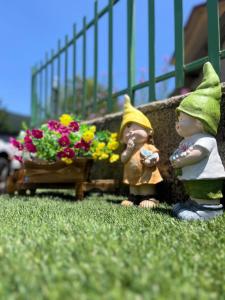 two figurines standing next to a planter with flowers at Casa dello Sciatore Lorica in Lorica