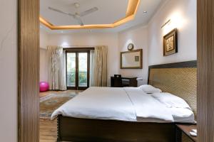 a bedroom with a bed and a ceiling fan at Avanti Tenantry-Luxurious Service Apartments in New Delhi