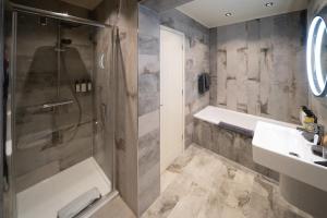 a bathroom with a shower and a tub and a sink at The Pier Hotel in Harwich +59 photos