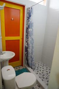 a bathroom with a toilet and a sink and a shower at Golden Frog Manizales in Manizales