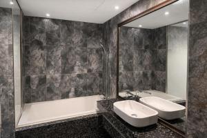 a bathroom with a tub and a sink and a mirror at Zenith Tourist Hotel in Bucheon