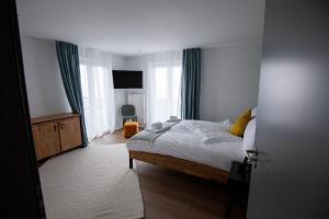 a bedroom with a bed and a window at Résidence Bellevue - Hôtel et Studios in Charmey