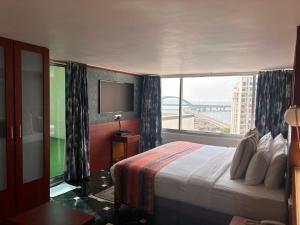a hotel room with a bed and a large window at Hiltop Hotel in Mumbai +58 photos