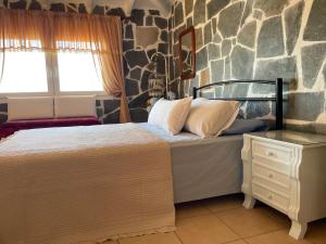 a bedroom with a bed and a stone wall at Blue Paradise Villa in Karianí
