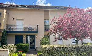 a house with a flowering tree in front of it at Balcon Vue Panoramique - Parking - Gare 200m in Vienne