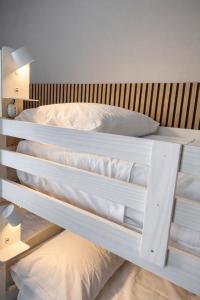 two white bunk beds in a room at BEDS&ROOMS TIBURTINA - Beds, Posti letto in Rome +2 photos
