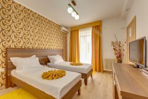a hotel room with two beds and a flat screen tv at Sutomore Akapulco Hotel in Sutomore