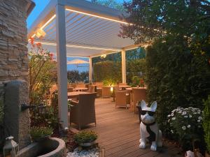 a patio with a cat statue under a pergola at Gourmet Hotel Zur Post in Saint-Vith +31 photos