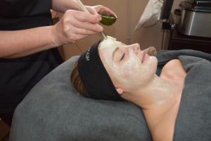 a woman getting her face shaved with a brush at Vakantiepark Ommerland in Ommen